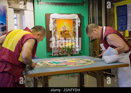 I monaci buddisti tibetani creano un mandala di sabbia a mano durante un evento alla Old City Gaol nel quartiere storico di Charleston, South Carolina. La complessa opera d'arte, che richiede diversi giorni, viene smantellata al termine Foto Stock