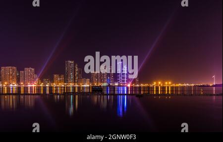 Splendida vista notturna panoramica del paesaggio urbano e del lungomare di Sharjah negli Emirati Arabi Uniti Foto Stock