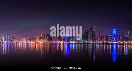 Splendida vista notturna panoramica del paesaggio urbano e del lungomare di Sharjah negli Emirati Arabi Uniti Foto Stock