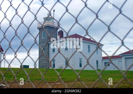 Fuoco selettivo del faro di Watch Hill a Westerly, Rhode Island, attraverso una catena di collegamento recinzione -03 Foto Stock