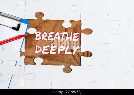 La scrittura che mostra il testo respira profondamente. Vetrina aziendale per prendere un grande respiro di aria nei polmoni per mettere in pausa la costruzione di un puzzle bianco incompiuto Foto Stock