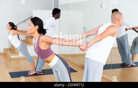 Lezioni di yoga per coppie nel moderno centro fitness Foto Stock