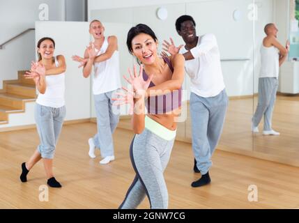 Felice donna asiatica godendo di danza attiva in classe di danza Foto Stock