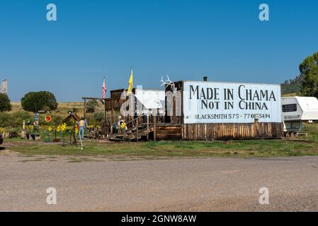 Il fabbro di Chama pubblicizza su un grande cartello dipinto sul lato di un edificio che i suoi beni sono "made in Chama non in Cina", Chama, New Mexico, USA. Foto Stock