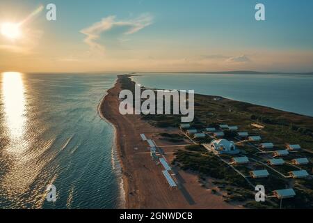 Lungo spit con spiaggia sabbiosa tra mare e liman al tramonto, vista aerea dal drone. Blagoveshchenskaya, regione Anapa, Russia. Foto Stock