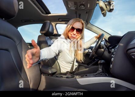 Donna che dà l'ascensore su strada Foto Stock