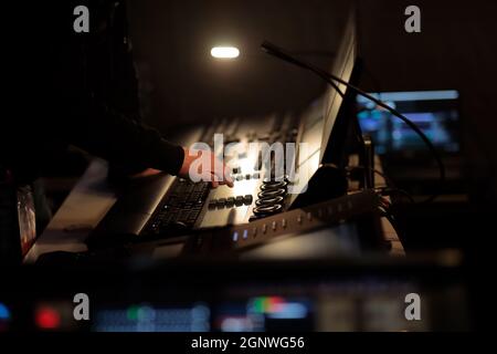L'operatore della scheda luminosa lavora sul pannello di controllo delle luci durante un evento live. Messa a fuoco selettiva. Foto Stock