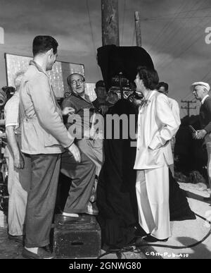 ROBERT RYAN Director FRITZ LANG e Continuity Girl DOROTHY HUGHES in set location Candid a Monterey California con Camera / Movie Crew durante le riprese di SCONTRO DI NOTTE 1952 regista FRITZ LANG giocare Clifford Odets sceneggiatura Alfred Hayes regista Nicholas Musuraca Wald / Krasna Productions / RKO radio Pictures Foto Stock