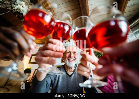 Persone multietniche felici che tostano e si divertono insieme a casa. Concetto di festa e festa Foto Stock