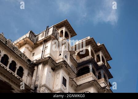 Foto architettonica vintage del Palazzo cittadino di colore giallo a Udaipur sotto il cielo blu Foto Stock