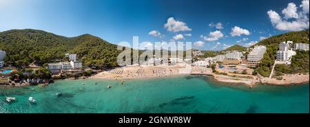 Foto aerea panoramica grandangolare di grande formato dell'isola spagnola di Ibiza che mostra la bella spiaggia e alberghi vacanze sulla spiaggia di Cal Foto Stock