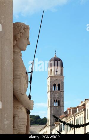 Orlando la colonna, più antico conservato scultura secolare in Dubrovnik, Croazia. Chiesa francescana in background. Foto Stock