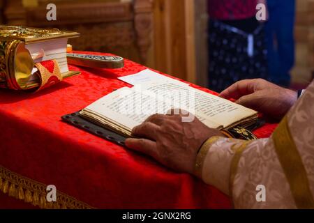 Un sacerdote che tiene la Bibbia in un rituale cristiano. Celebrata cristiana Foto Stock