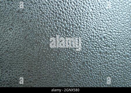 Colore grigio brillante texture vetrosa, con gocce d'acqua su di essa. Acqua goccia sfondo vetroso Foto Stock