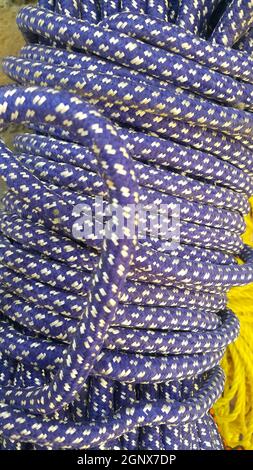 Closeup di corde di plastica intrecciate di colore brillante. Matasse o bobina di corda di plastica colorata lucida intrecciata che vengono utilizzati per l'arrampicata e il serraggio di accoppiamento Foto Stock