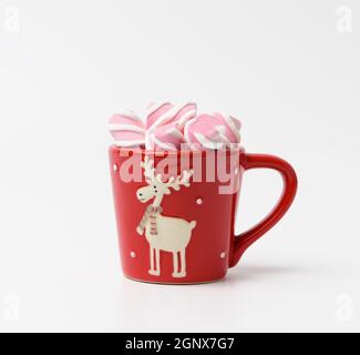 coppa in ceramica rossa con cacao e marshmallows su sfondo bianco, primo piano Foto Stock