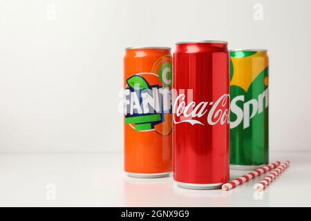 Odessa, Ucraina - 23 settembre 2021: Coca - Cola, Sprite e Fanta lattine, e cannucce su tavola bianca. Foto Stock