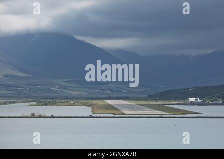 Vista dalla fine della pista ad Akureyri aeroporto in Islanda. Un piccolo aereo è tenuto spento. Foto Stock