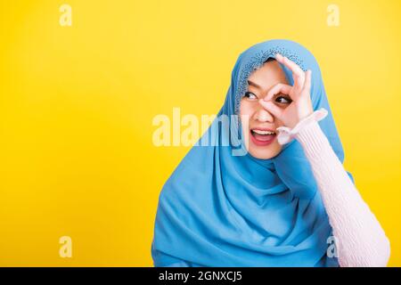 Arabo musulmano asiatico, Ritratto di felice bella giovane donna islam religioso indossare velo hijab sorriso divertente mostra gesti dita in simbolo di gesto okay Foto Stock