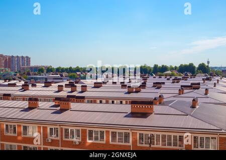 Tetti di case in una zona residenziale di una piccola città. Cottage villaggio in città in una giornata estiva soleggiata. Foto Stock