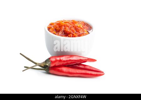 Pasta di peperoncino rosso caldo in ciotola e peperoncino isolato su sfondo bianco. Foto Stock