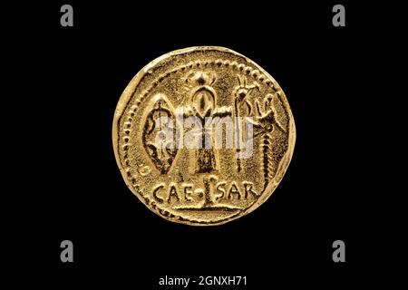 Lato opposto di una replica romana Aureus Gold Coin di Julius Cesare con un Trofeo di armi galliche colpito tra 48-47 BC tagliato e isolato su un blac Foto Stock