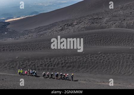 Un gruppo di turisti in un'escursione guidata fino al Monte Etna, Sicilia, Italia Foto Stock