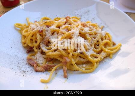 Pasta carbonara servita all'aperto in un ristorante pizzaria a Lucca, Italia Foto Stock