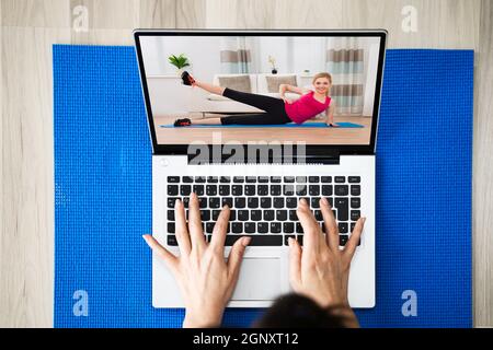 Guardare online Yoga Video programma esercizio sul computer portatile a. Casa Foto Stock