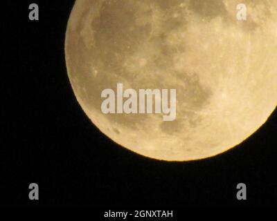 Luna della Terra che si illumina su sfondo nero. La Luna in primo piano su un cielo notturno nero girato attraverso una teleobiettivo fotocamera. Foto Stock