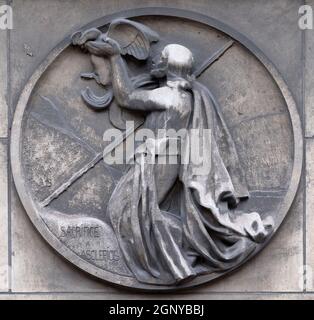 Il sacrificio di Esculapio, dio della medicina in greco antico religione e mitologia. Bassorilievo in pietra per la costruzione del Faculte de Medicina Parigi, Francia Foto Stock