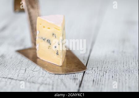 Incuneamento di formaggio blu sotto una crosta di muffa bianca Foto Stock