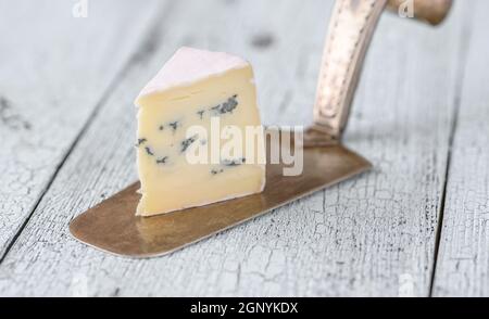 Incuneamento di formaggio blu sotto una crosta di muffa bianca Foto Stock