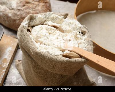 farina di grano bianco in un piccolo sacco di burlap, primo piano Foto Stock
