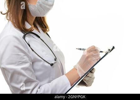 Il medico scrive con una penna in una clipboard su un pezzo di carta Foto Stock