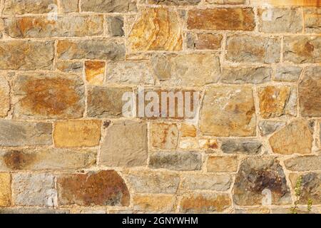 Primo piano di un muro di pietra in pietra gallese. Foto Stock