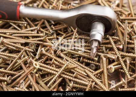 Cacciavite giacente su un mucchio di viti. L'attrezzo e attrezzature Foto Stock