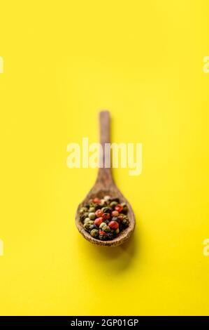 Spezie fragranti in un primo piano a cucchiaio, isolate su sfondo giallo. Cibo vegetariano biologico, assortimento di generi alimentari, prodotti ecologici naturali, stile di vita sano Foto Stock
