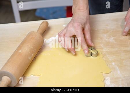 Tagliare i biscotti fatti in casa a forma di piccolo cuore come una sorpresa per San Valentino. Foto Stock