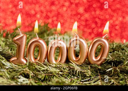 10000 carta dei follower. Modello per i social network, blog. Fatto da oro candele bruciare su bokeh festivo scintillante sfondo. 10k comunità online fa Foto Stock