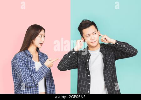 Donna furia arrabbiata urlando e l'uomo copre le orecchie. Foto Stock