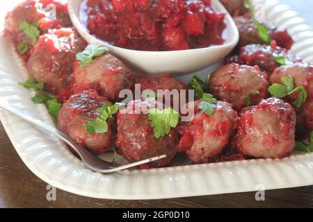 Polpette calde con salsa di mirtilli su piatto bianco . Foto Stock