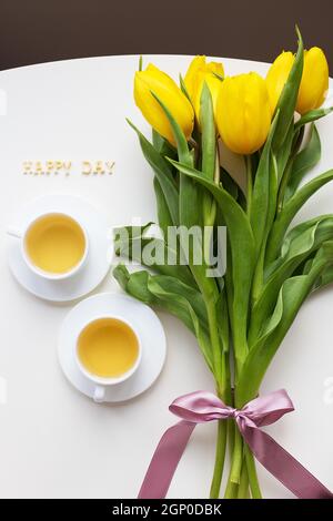 Bella tulipani gialli sul tavolo, l'iscrizione Happy day Foto Stock