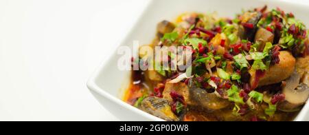 Un stufato di carne, patate, funghi e un mix di peperoni serviti in una ciotola bianca, pasto delizioso Foto Stock