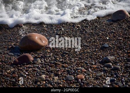 Set di rocce sulla riva della spiaggia, sfondo non focalizzato, nessuno, primo piano, soleggiato, grandi e piccole pietre Foto Stock