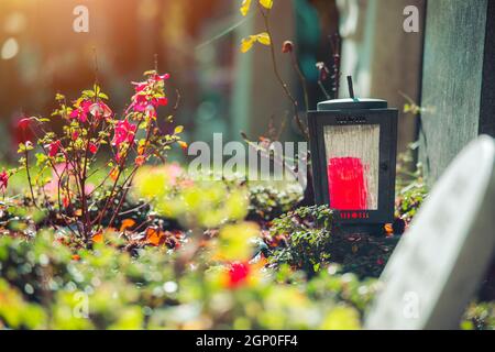 Candela in una lanterna di ferro su una tomba in un cimitero Foto Stock
