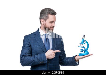 uomo d'affari puntando dito sul microscopio moderno isolato su bianco, scienza e commercio. Foto Stock