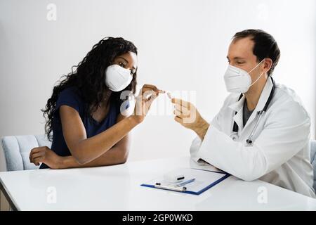 Assistenza per l'udito di pazienti africani in clinica con maschera facciale Foto Stock
