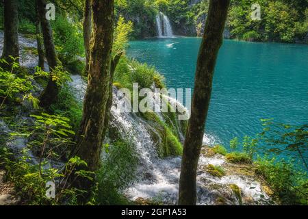 Cascate che scendono dalle rocce e che scorrono verso il lago di colore turchese. Parco Nazionale dei Laghi di Plitvice Patrimonio dell'Umanità dell'UNESCO in Croazia Foto Stock