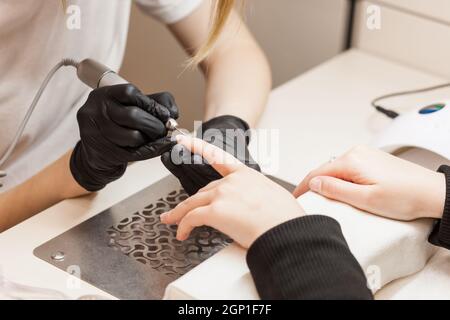 Belle mani femminili durante una procedura di cura delle unghie. Foto Stock